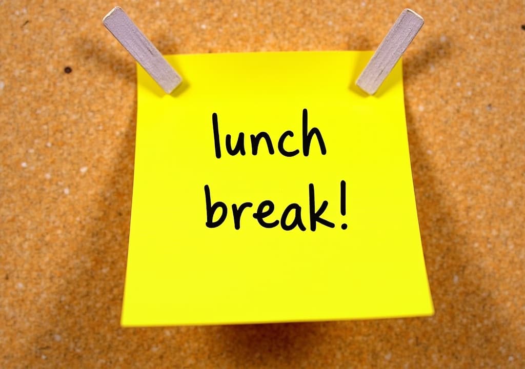  good quality, high quality, bright yellow sticky note with "lunch break!" message pinned on corkboard background