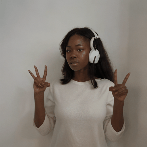 A high quality professional video of a  black woman standing in front of a white wall doing the American Sign Language gesture for the word “Hello” against an all white background. 