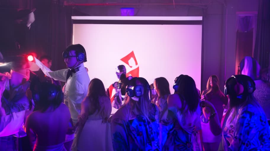  soviet style prom night party, set in the 1980s, with a dj booth in the center of the room. the dj is dressed in a pioneer uniform with square glasses, headphones, complete with a red tie and a enthusiastic expression. the room is filled with retro soviet decorations, including hammer and sickle symbols, soviet flags, and vintage posters. the walls and ceiling are adorned with neon lights, casting a colorful glow over the scene. the overall mood is one of nostalgia and joy, capturing the excitement and energy of a soviet era prom night.