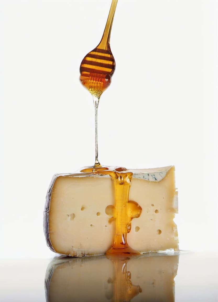  food photography style the cheese is poured with honey with beautiful reflection . appetizing, professional, culinary, high resolution, commercial, highly detailed, film photography style