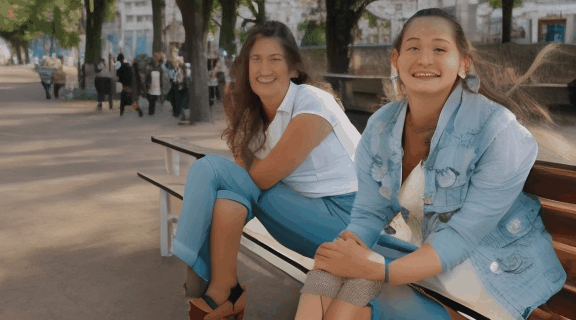 Girl smiling and sitting on bench, ultra HD video.