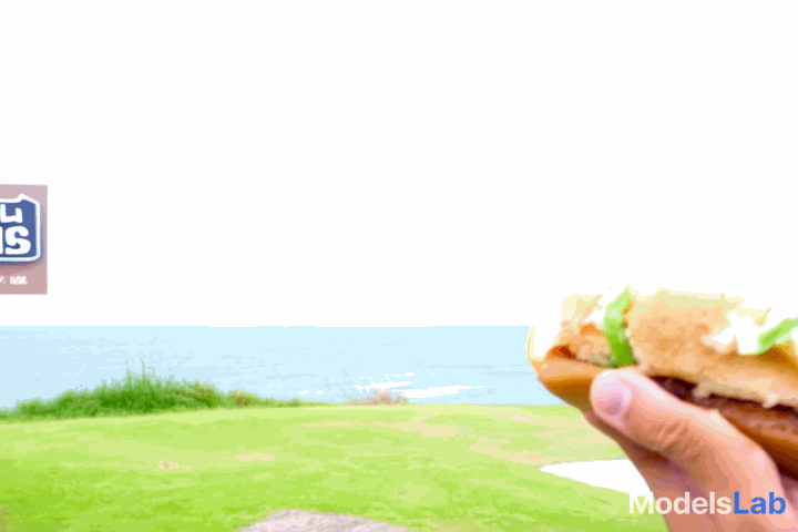 A cinematic real view of a person holding a Shawarma sub in front of the ocean in Antigonish of Nova Scotia. A sign is there with Grape Leaves restaurant. The person is enjoying the bite.